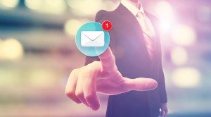 Businessman pointing at an email icon on blurred city background